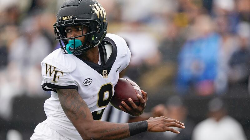 Wake Forest wide receiver A.T. Perry looks back for defenders as he runs to the end zone on a...