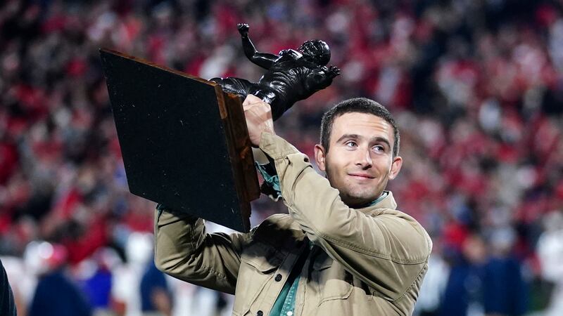 Former Georgia and current Los Angeles Rams quarterback Stetson Bennett holds a trophy as he...