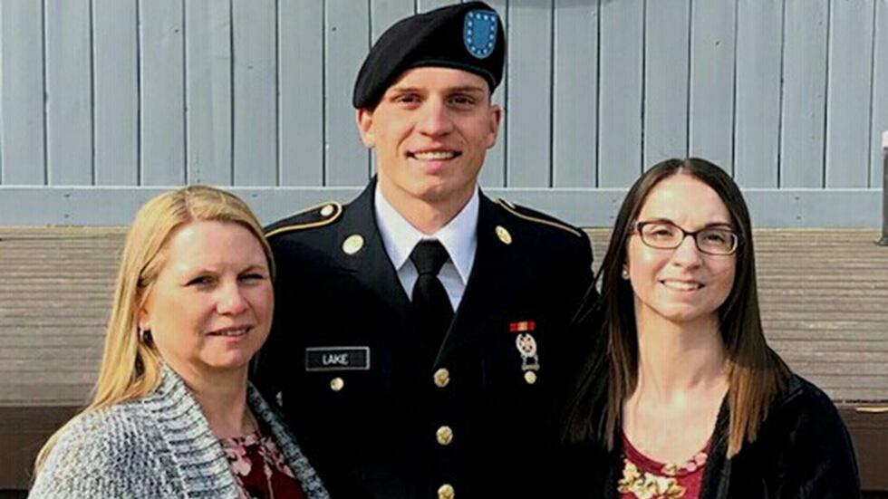 Gavin Lake (middle) smiles after graduating from US Army basic training.