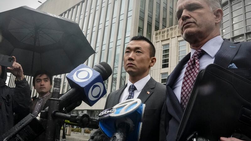 NYPD officer Baimadajie Angwang, center, a naturalized U.S. citizen born in Tibet, and his...