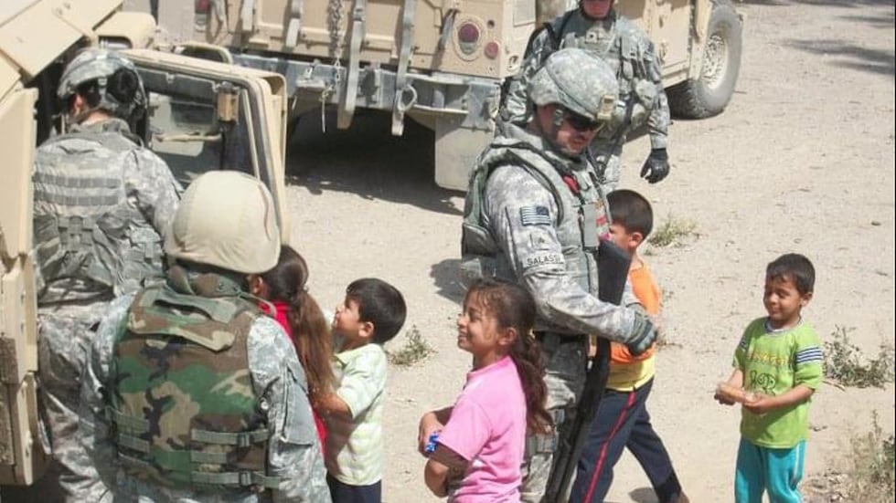 Garrett Salassi greets children while serving in Iraq.