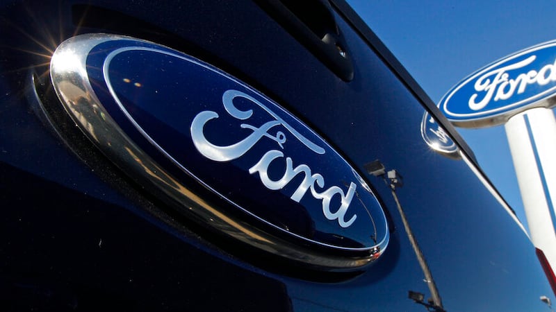 A Ford logo and Ford dealership sign are displayed at Salem Ford in Salem, N.H., Tuesday, Oct....