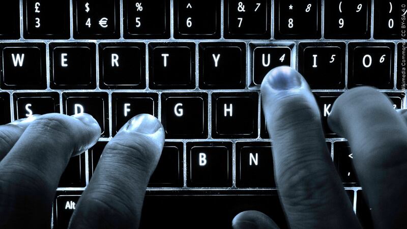 Hands on a backlit keyboard